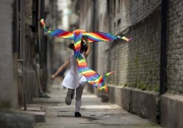 A child runs with a kite.